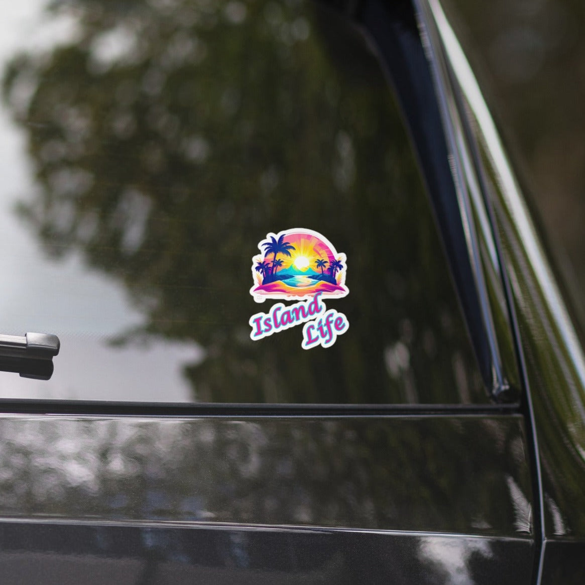 A picture of the back window of a black car with a sticker on the window. The sticker is a colorful picture of a tropical island paradise and the text Island Life underneath - 4 inch