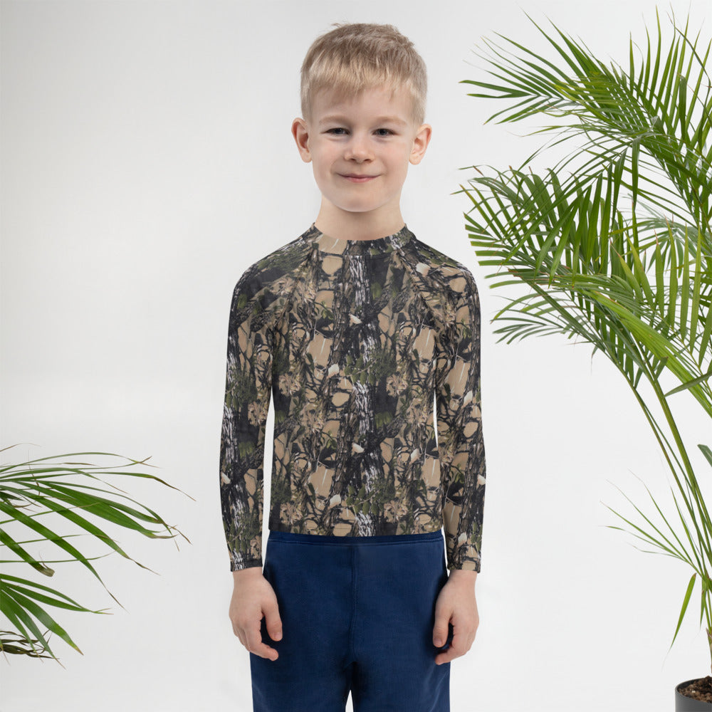 A picture of a little boy wearing a Camouflage all over print kids rash guard - front side