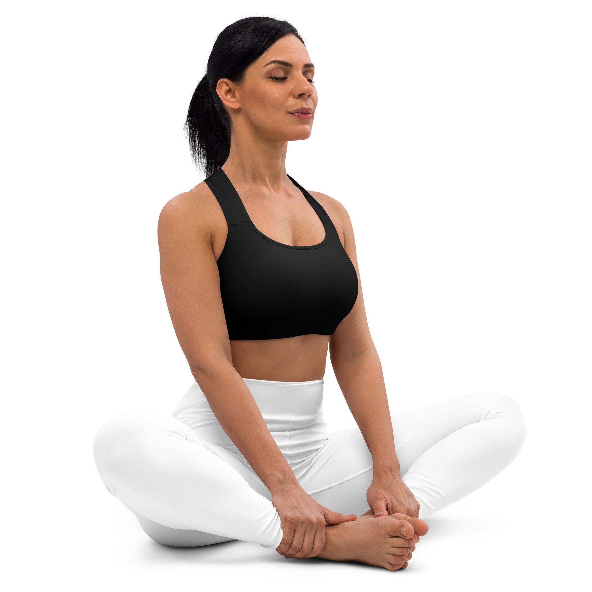 A picture of a women on the floor in a yoga pose wearing a Black padded sports bra - crop top - right side