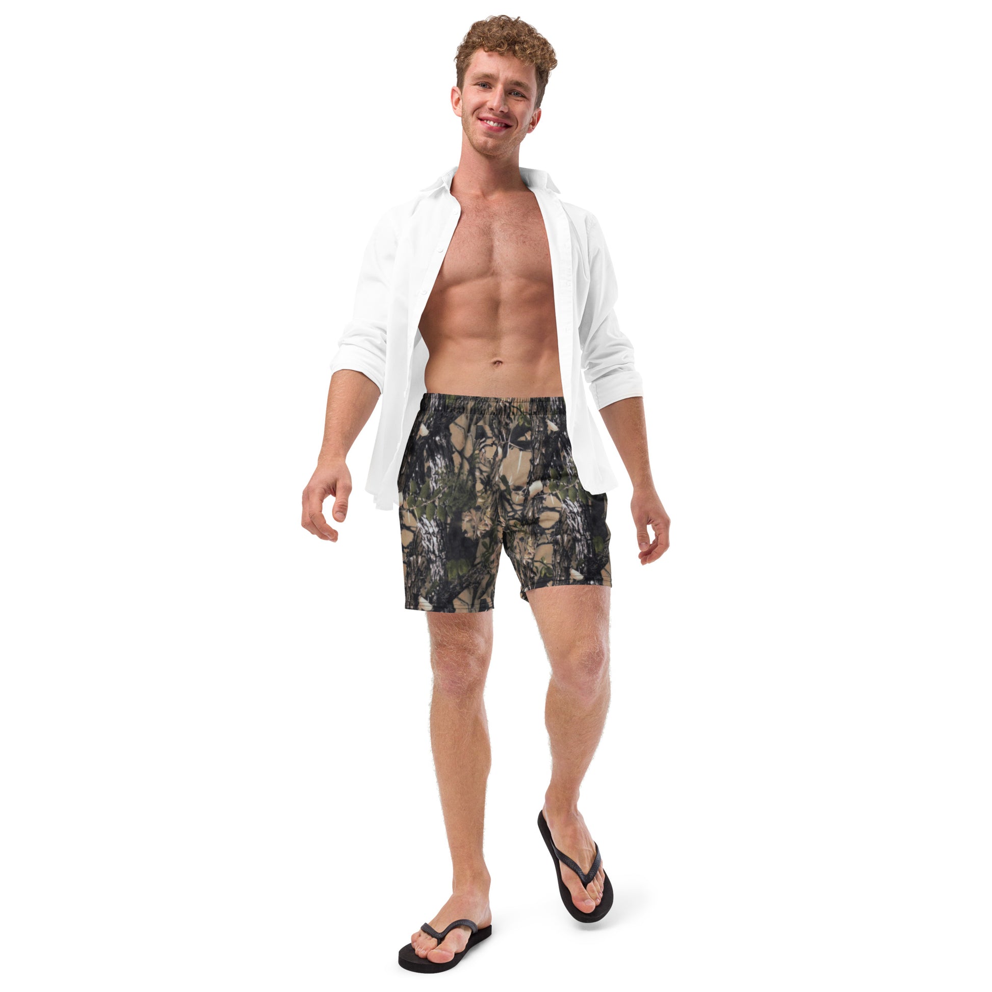 A picture of a man wearing a open front buttoned shirt and Camouflage all over print swim trunks,  with thongs on his feet - front side 