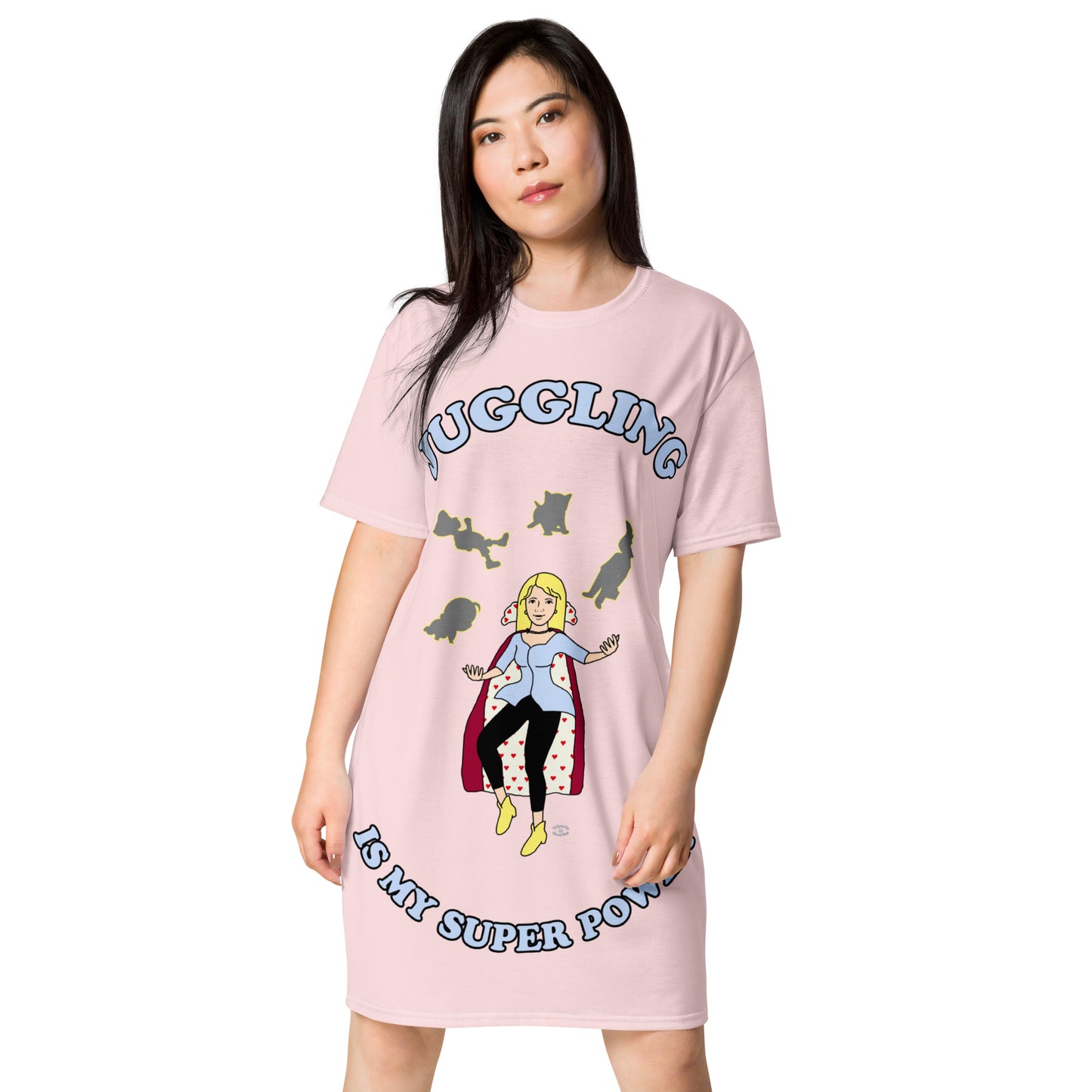 A women wearing a short sleeve tshirt dress which has on the front a cartoon women in a cape juggling her family like a jester and the text Juggling Is My Super Power - front - light pink
