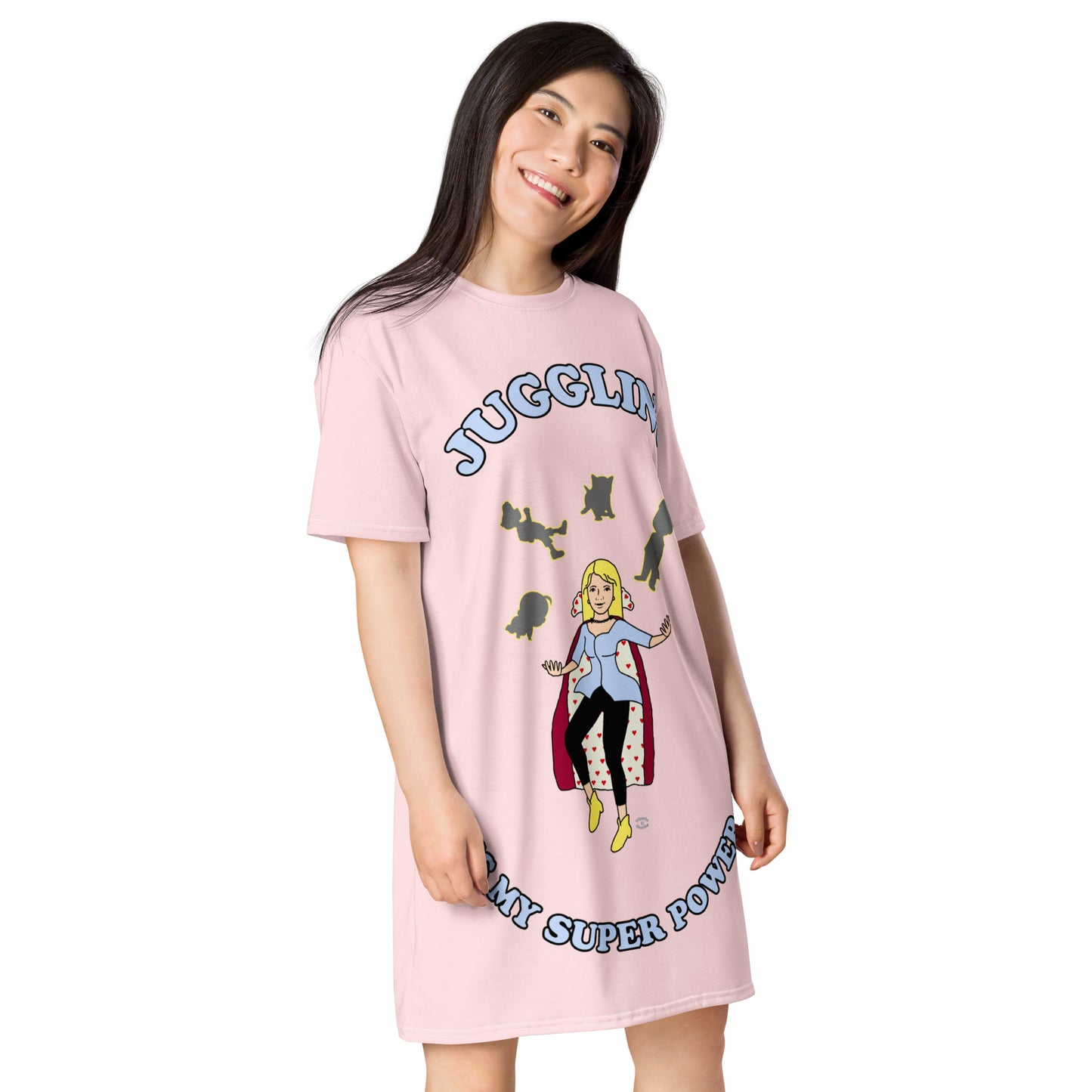 A women wearing a short sleeve tshirt dress which has on the front a cartoon women in a cape juggling her family like a jester and the text Juggling Is My Super Power - right front - light pink