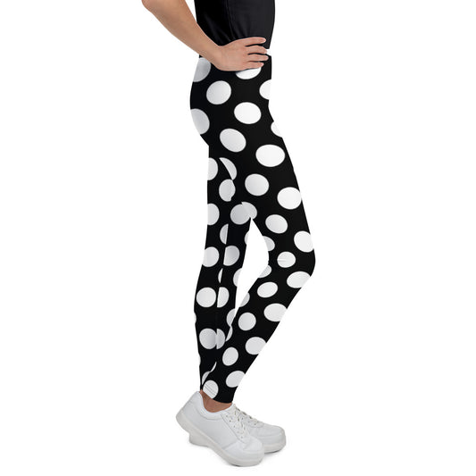 Youth pictured from the waist down wearing Black and white spotted polka-dot leggings - right front