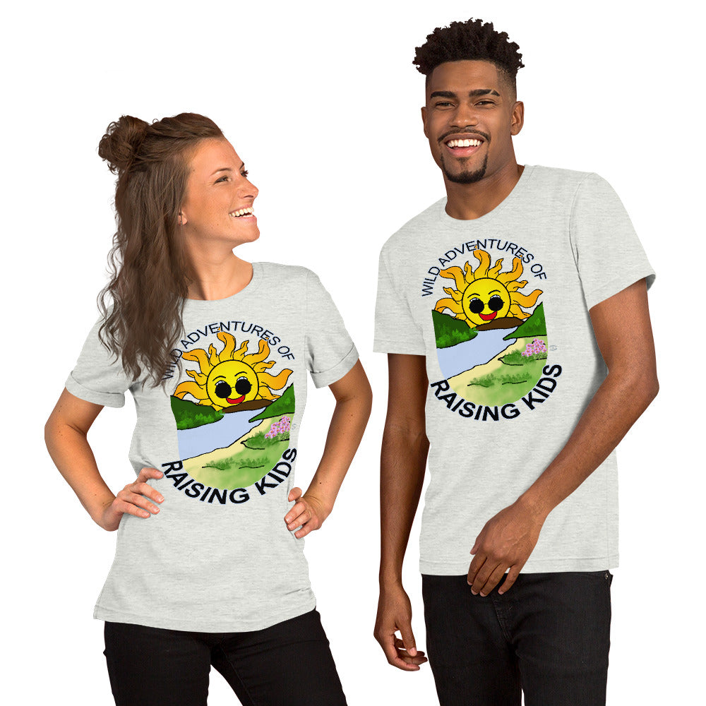 A man and a woman wearing matching tshirts with a picture of the sun coming up over the mountains with sunglasses on and a little stream gently flowing trees and bushes can be seen on the closer mountains and a small beach with some flowers are on the closes bank around the outside of the picture is written "Wild Adventures of Raising Kids" unisex tshirt - ash grey front