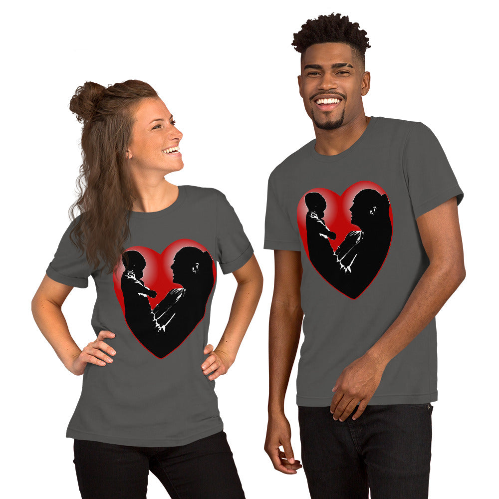 A man and a women wearing matching short sleeve tshirt with a picture on the front of a mother holding up a baby in silhouette with white light shining from behind and a red love heart framing them - Front - asphalt