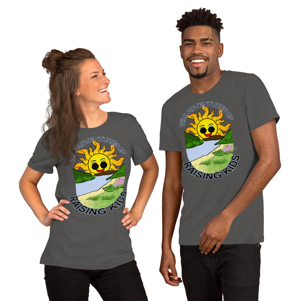 A man and a woman wearing matching tshirts with a picture of the sun coming up over the mountains with sunglasses on and a little stream gently flowing trees and bushes can be seen on the closer mountains and a small beach with some flowers are on the closes bank around the outside of the picture is written "Wild Adventures of Raising Kids" unisex tshirt - asphalt front
