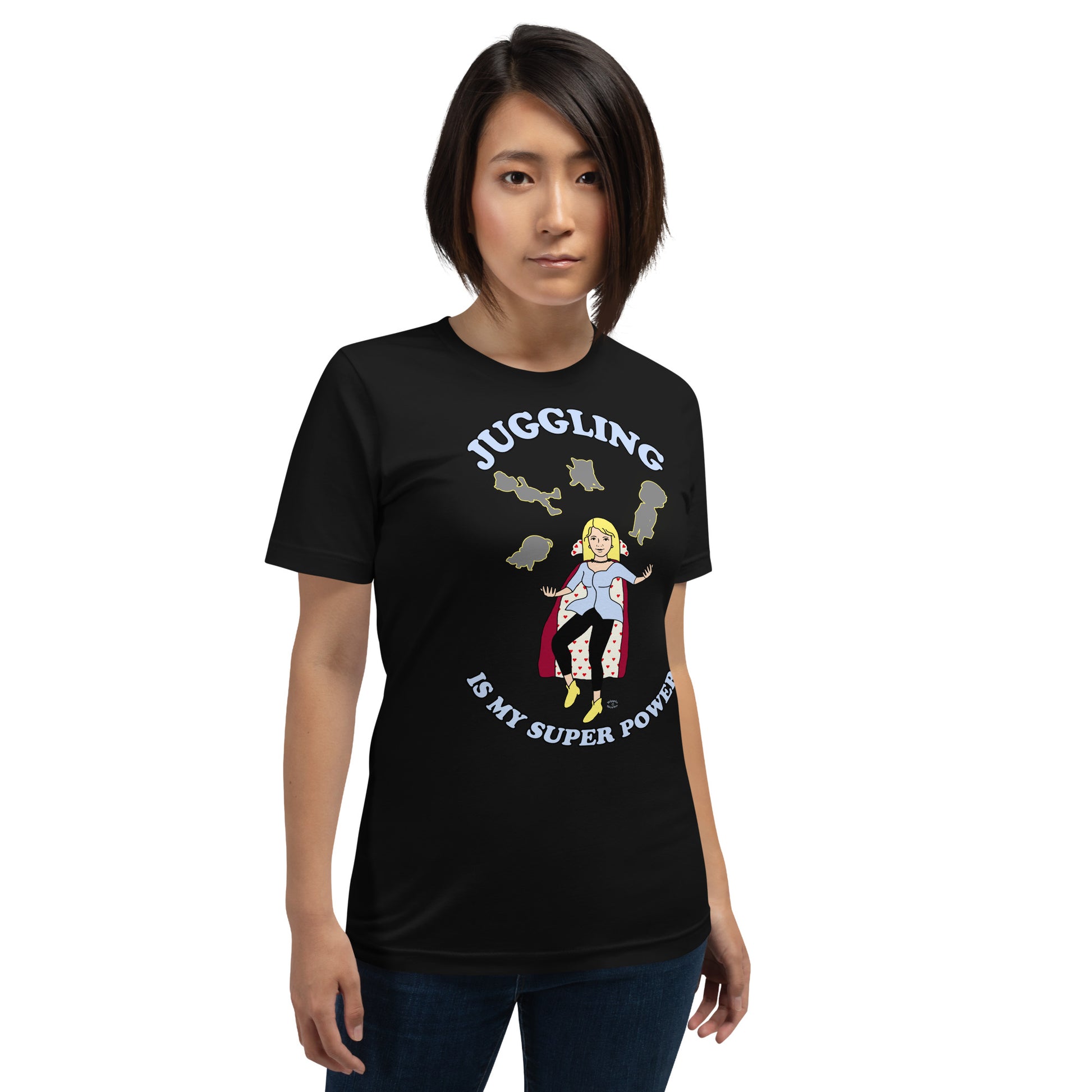 A women wearing a unisex short sleeve tshirt which has on the front a cartoon women in a cape juggling her family like a jester and the text Juggling Is My Super Power - front - black