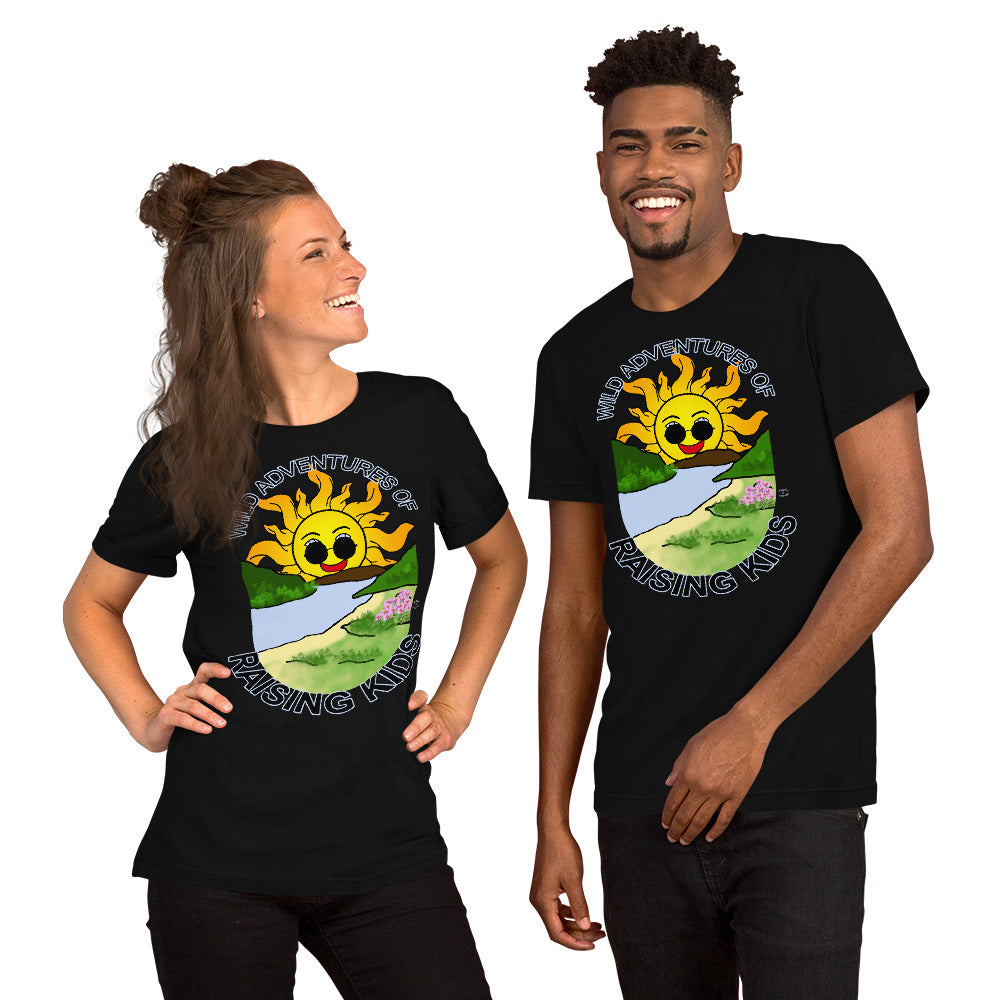 A man and a woman wearing matching tshirts with a picture of the sun coming up over the mountains with sunglasses on and a little stream gently flowing trees and bushes can be seen on the closer mountains and a small beach with some flowers are on the closes bank around the outside of the picture is written "Wild Adventures of Raising Kids" unisex tshirt - black front