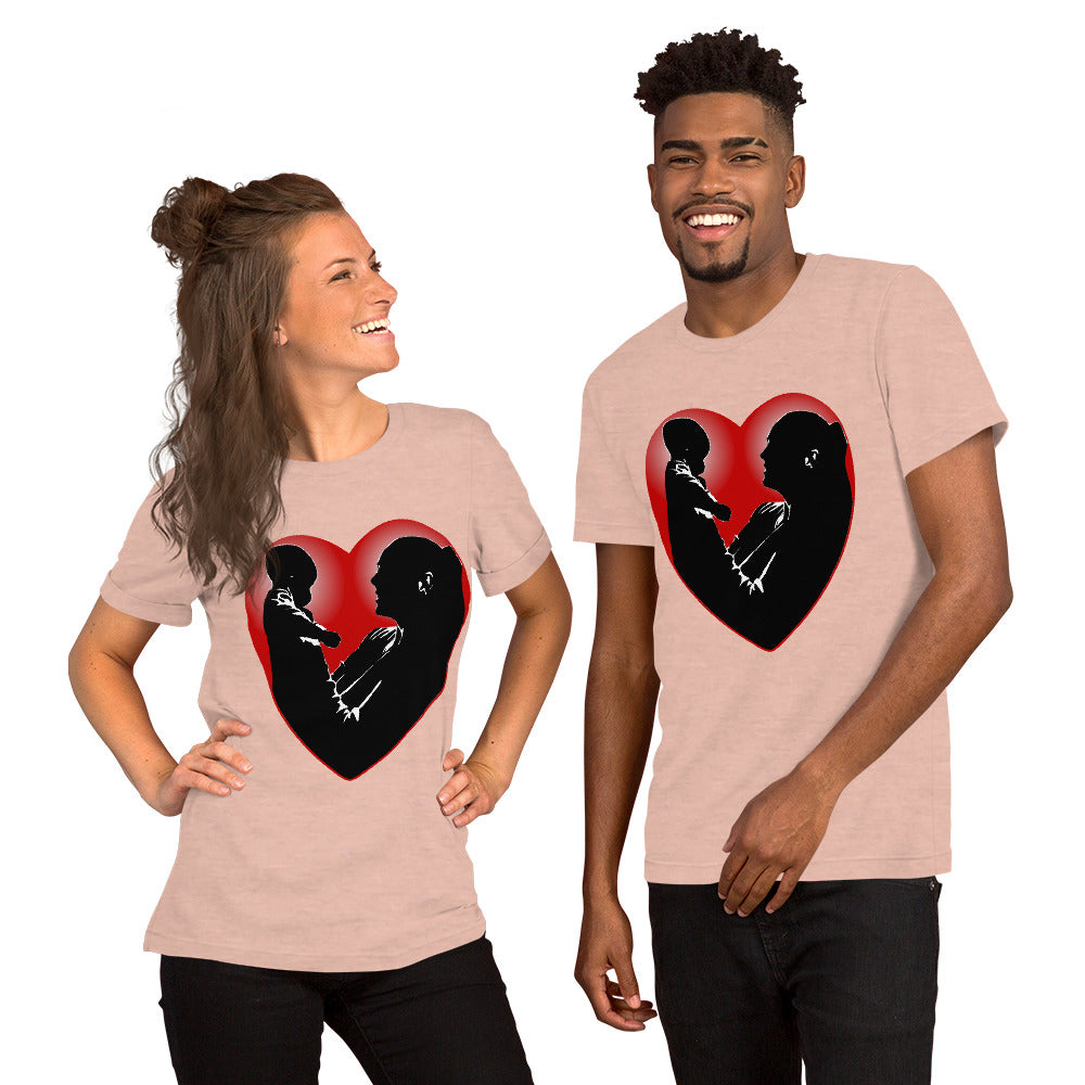 A man and a women wearing matching short sleeve tshirt with a picture on the front of a mother holding up a baby in silhouette with white light shining from behind and a red love heart framing them - Front - heather prism peach