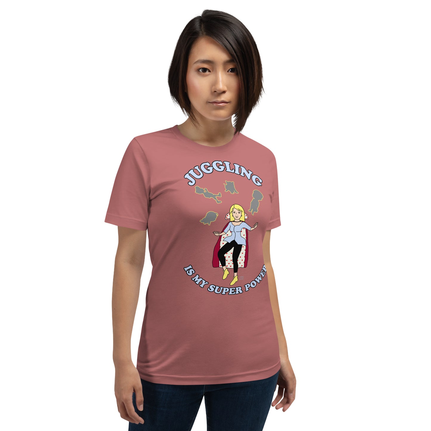 A women wearing a unisex short sleeve tshirt which has on the front a cartoon women in a cape juggling her family like a jester and the text Juggling Is My Super Power - front - mauve