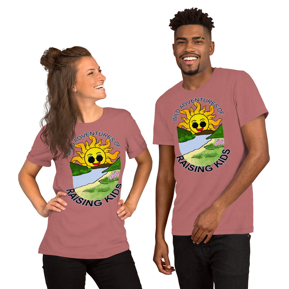 A man and a woman wearing matching tshirts with a picture of the sun coming up over the mountains with sunglasses on and a little stream gently flowing trees and bushes can be seen on the closer mountains and a small beach with some flowers are on the closes bank around the outside of the picture is written "Wild Adventures of Raising Kids" unisex tshirt - mauve front