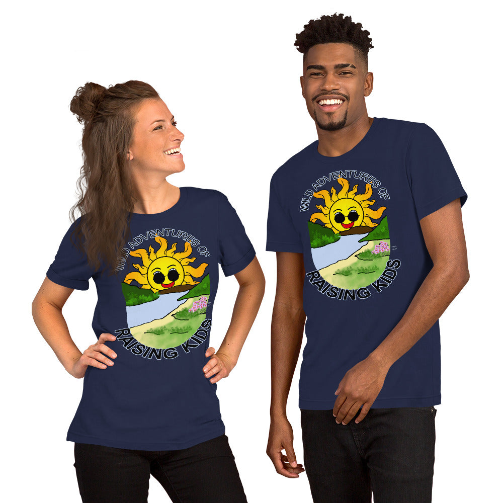 A man and a woman wearing matching tshirts with a picture of the sun coming up over the mountains with sunglasses on and a little stream gently flowing trees and bushes can be seen on the closer mountains and a small beach with some flowers are on the closes bank around the outside of the picture is written "Wild Adventures of Raising Kids" unisex tshirt - navy front