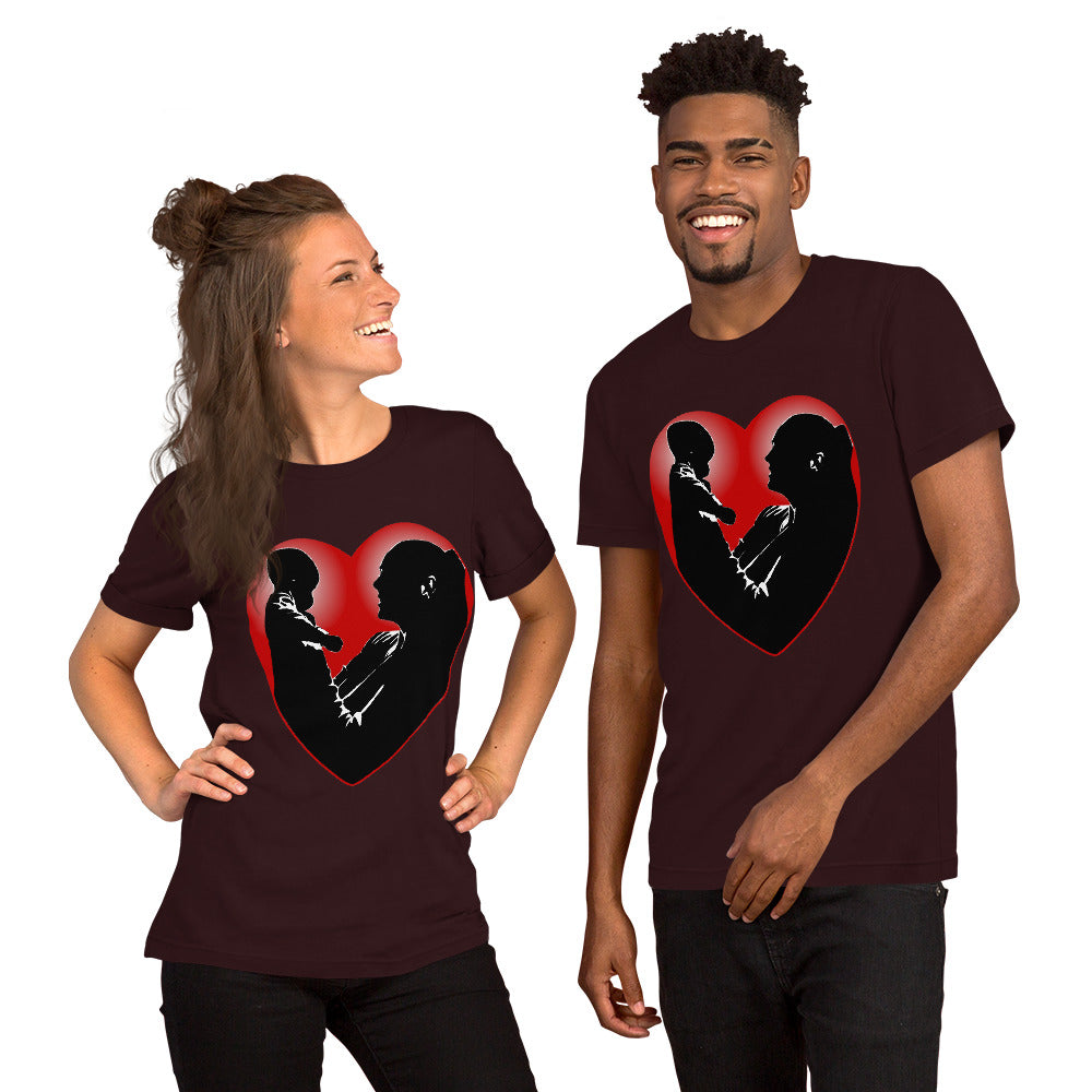 A man and a women wearing matching short sleeve tshirt with a picture on the front of a mother holding up a baby in silhouette with white light shining from behind and a red love heart framing them - Front - oxblood black