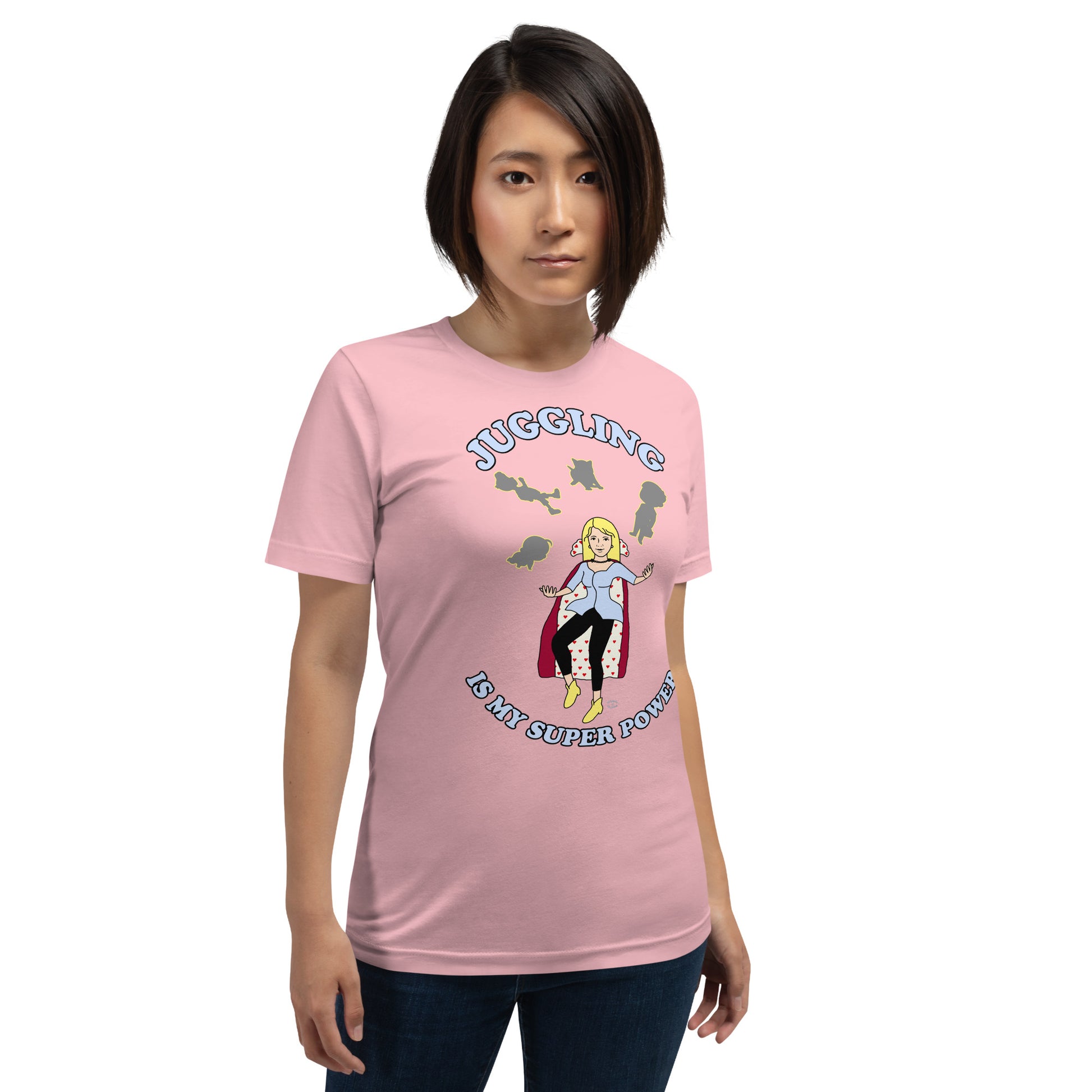 A women wearing a unisex short sleeve tshirt which has on the front a cartoon women in a cape juggling her family like a jester and the text Juggling Is My Super Power - front - pink