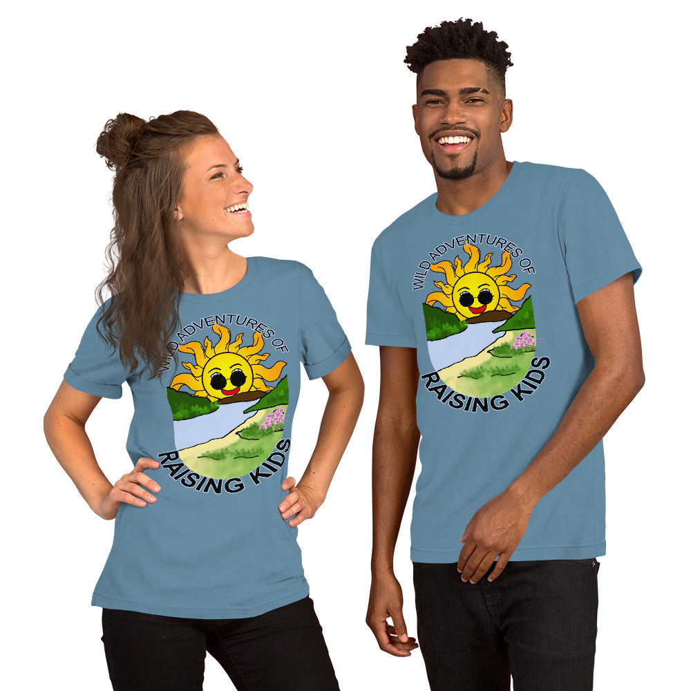 A man and a woman wearing matching tshirts with a picture of the sun coming up over the mountains with sunglasses on and a little stream gently flowing trees and bushes can be seen on the closer mountains and a small beach with some flowers are on the closes bank around the outside of the picture is written "Wild Adventures of Raising Kids" unisex tshirt - steel blue front